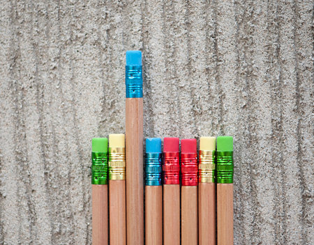 Row of color pencils on grey  background