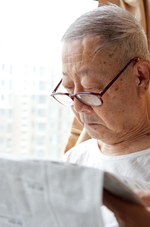 a senior man is reading newspaperの写真素材