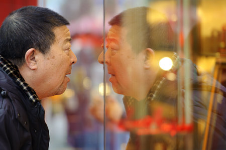 CHENGDU - FEB 7: A man stop to look in the window of a gold shop on a busy pedestrian shopping street in downtown during chinese new year on Feb 7, 2011 in Chengdu, China.のeditorial素材