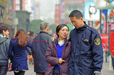 CHENGDU - FEB 7: A young couple pass through a busy pedestrian shopping street in downtown during chinese new year on Feb 7, 2011 in Chengdu, China.のeditorial素材
