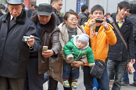 CHENGDU - FEB 7: People were shooting photos of tulips on a busy pedestrian shopping street in downtown during chinese new year on Feb 7, 2011 in Chengdu, China.のeditorial素材