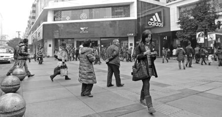 CHENGDU - FEB 7: A girl pass through a busy pedestrian shopping street in downtown during chinese new year on Feb 7, 2011 in Chengdu, China.のeditorial素材