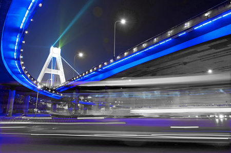 High-speed vehicles blurred trails on urban roads under overpass