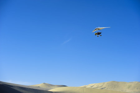powered glider flying above the desert
