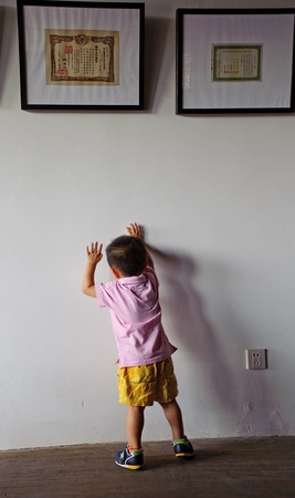 cute boy standing below a pictureの写真素材