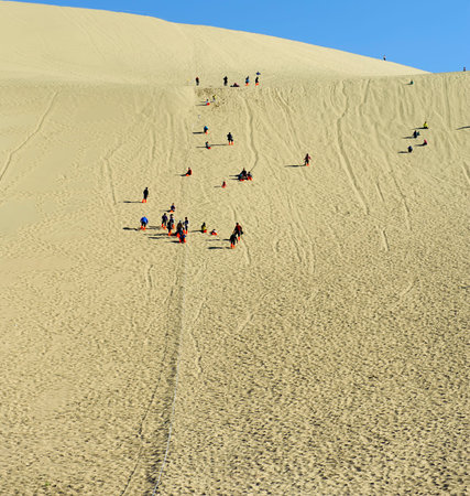 tourists to climb the sand dunesの写真素材