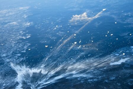 Patterns of snow and quickly frozen water on the fresh thin river ice. Beginning of winterの写真素材