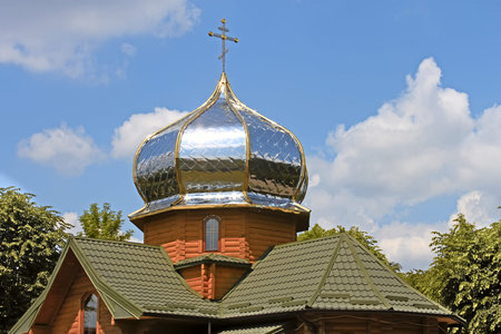 New modern small wooden church with a gilded dome is among the trees. Lviv, Ukraineの写真素材