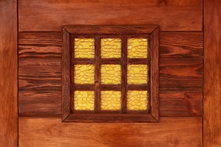 Yellow decorative stained-glass window in the reddish lacquered wooden frameの写真素材
