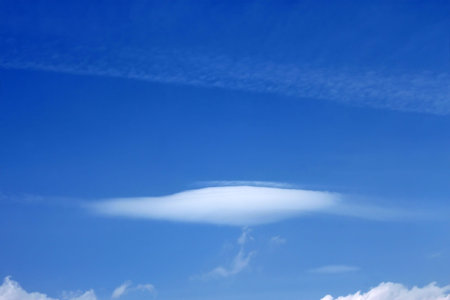 Light cloud in the shape of plate on the background of a blue skyの写真素材