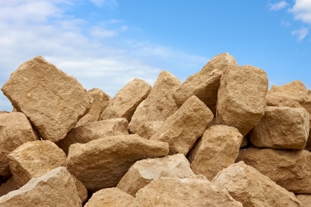 Heap of large shapeless blocks of limestone against the background of blue skyの写真素材