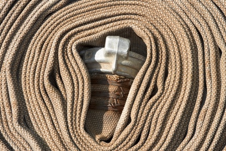 Old rolled fire hose with nozzle close-upの写真素材