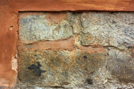 Fragment of old stone wall with plaster shelledの写真素材