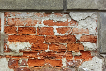 Fragment of old brick wall with plaster shelledの写真素材