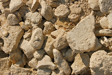 Heap of limestone stones and sand in bright sunlight as a textureの写真素材