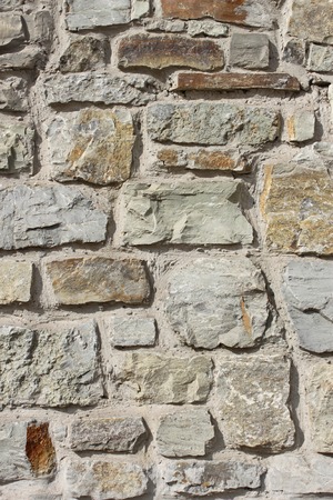 Wall of large rough granite boulders fortified by cement, vertical photoの写真素材