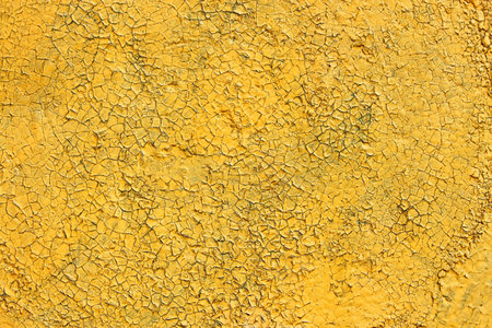Multilayer painted shelled and cracked yellow surface outdoors as the textureの写真素材