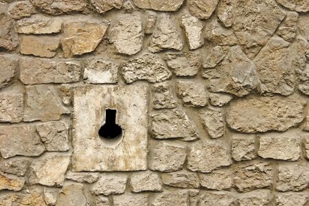 Loophole in medieval masonry stone fortress close-up in Lviv, Ukraineの写真素材