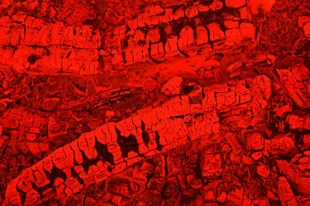 Firewood background with smoldering charcoal embers in red color, top view
