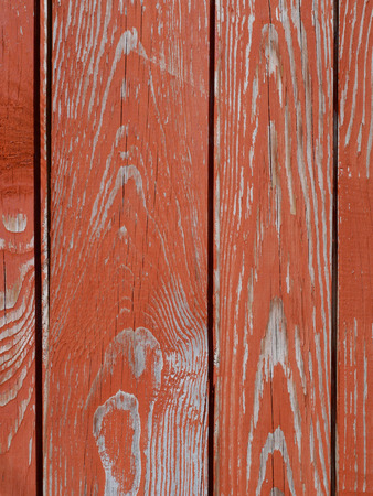 Fragment of old wooden fence with peeling red paintの写真素材