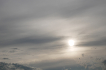 Gray moody clouds and the sun shines through the overcastの写真素材