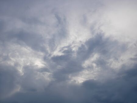 Grey and bluish dramatic cloudscape with various density chaotic thundercloudsの写真素材