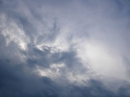 Dark and light bluish tragic cloudscape with various density chaotic thundercloudsの写真素材