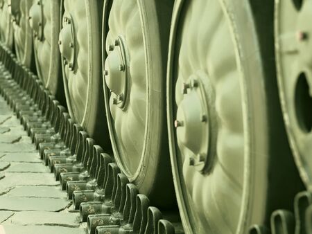 Military equipment; undercarriage of tracked wheel of tank; close-up; toned in greenの写真素材
