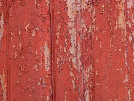 Background of old wooden fence with shelled red paintの写真素材