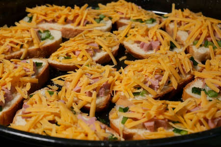 Detail of Pizza during the preparing for cooking with ingredients of sausages, long sliced carrot, green onion leaves and without some other components, close-upの写真素材