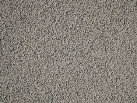 Fragment of solid concrete bumpy grainy plaster wall painted in turquoise color with many tine details, close-upの写真素材