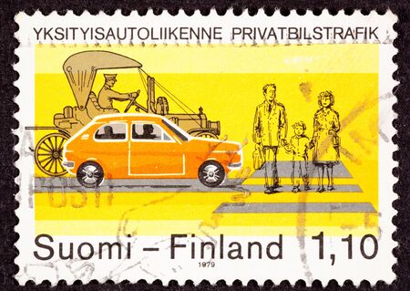 Canceled Finland Postage Stamp about Traffic Safety.  Shows family of three crossing a street at a crosswalk.  Two cars modern subcompact and a Model-Tの写真素材