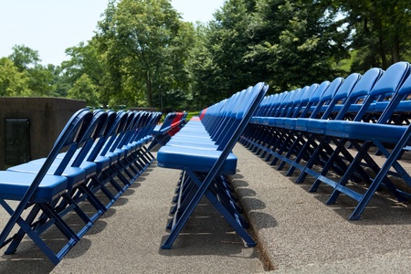 Outdoor rows of blue and red metal folding chairsの写真素材