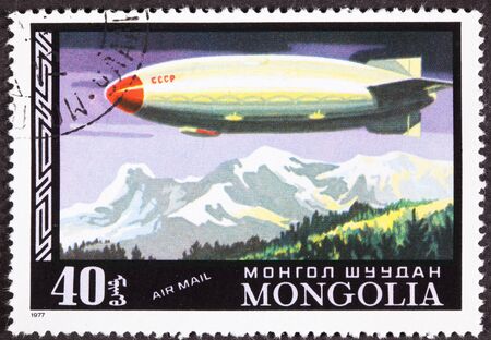 Historic fligth of a Soviet Zeppelin flying over a mountain range canceled Mongolian Air Mail Postage Stampの写真素材
