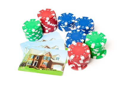 Playing cards with house printed on them next to stacks of poker chips.  Gambling on real estate theme.のeditorial素材