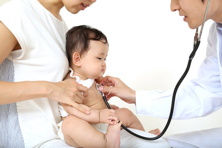 Placing a stethoscope on a baby's chest is an image of pediatric practiceの写真素材