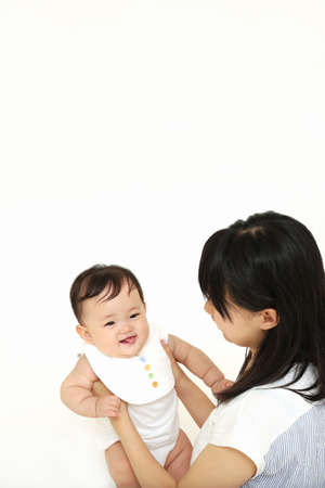 Asian mother and baby on white background, closeup. Happy family conceptの写真素材