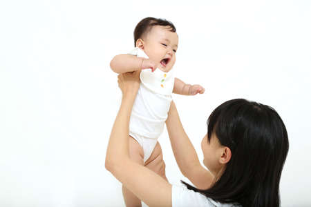 Mother playing with her baby on white background. Happy family concept.の写真素材