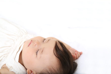 Beautiful baby sleeping on white bed, closeup. Space for text