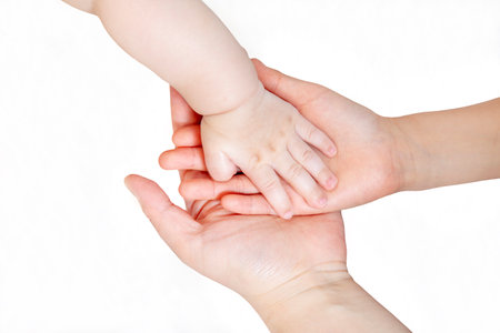 Baby and adult hands overlapping in front of white background. Family, affection imageの写真素材