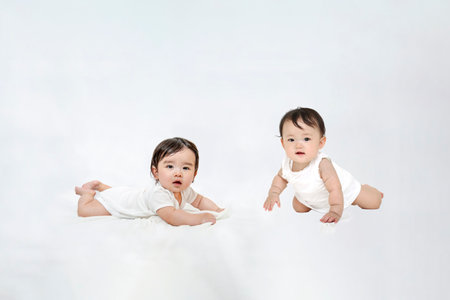 Two babies looking at the camera crawlingの写真素材