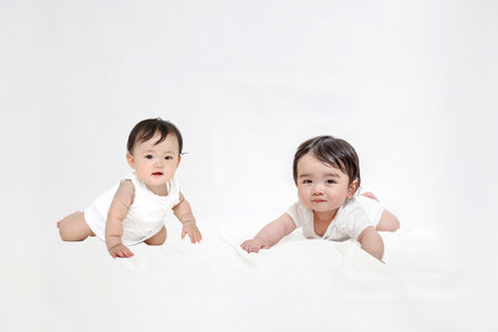 Two babies looking at the camera crawlingの写真素材