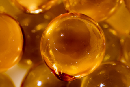 The photo of a magnificent texture of yellow bubbles obtained from spherical capsules of fish oil was taken in macro modeの写真素材