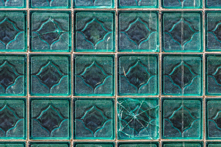 A beautiful horizontal texture of part of a glass transparent square brick wall in green hue is on the photoの写真素材