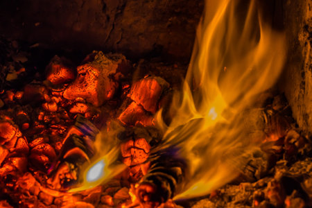 A beautiful horizontal texture of a burning fire on a black background with sparks is in the photo