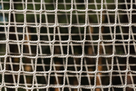 A white rope net on a playground is in summer