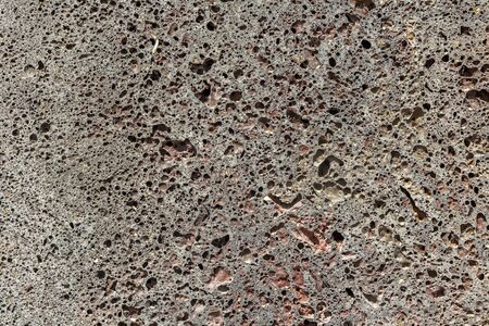A beautiful texture of orange stone pumice with holes is in the photoの写真素材