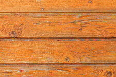 A beautiful horizontal texture of yellow and brown boards with knots and resin is in the photo