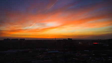 The City is on a sky background with orange and yellow sunset or sunrise