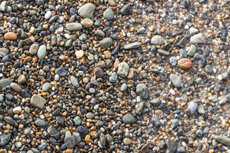 A Beautiful texture of colorful smooth stones is on the beach by sea